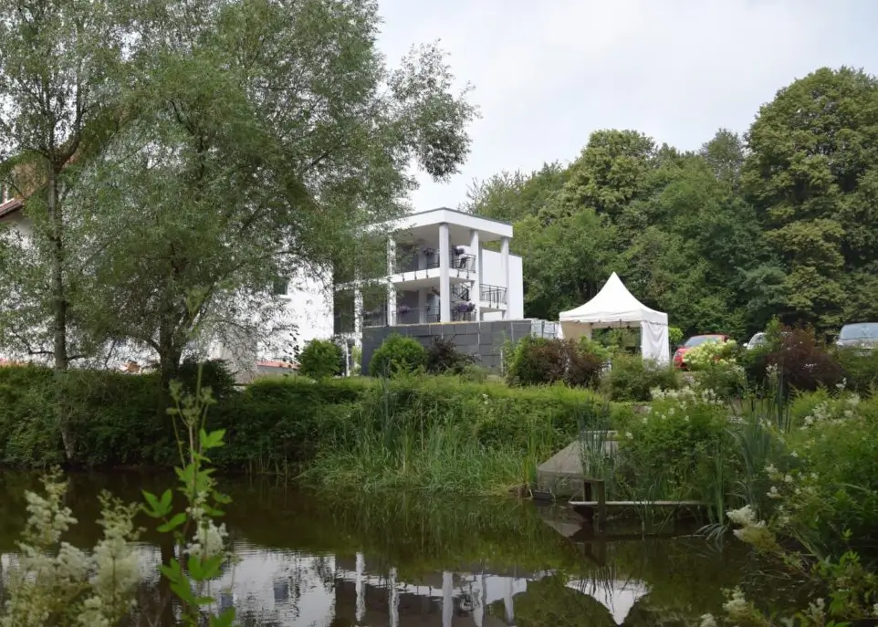Blick auf das Pflegeheim Haus Mühlberg in Krettnich mit einem Teich im Vordergrund